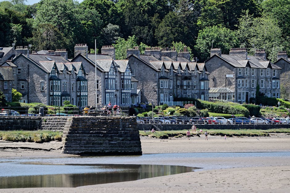 Picturesque view of traditional houses along the promenade in Arnside, with beach and estuary in the foreground.